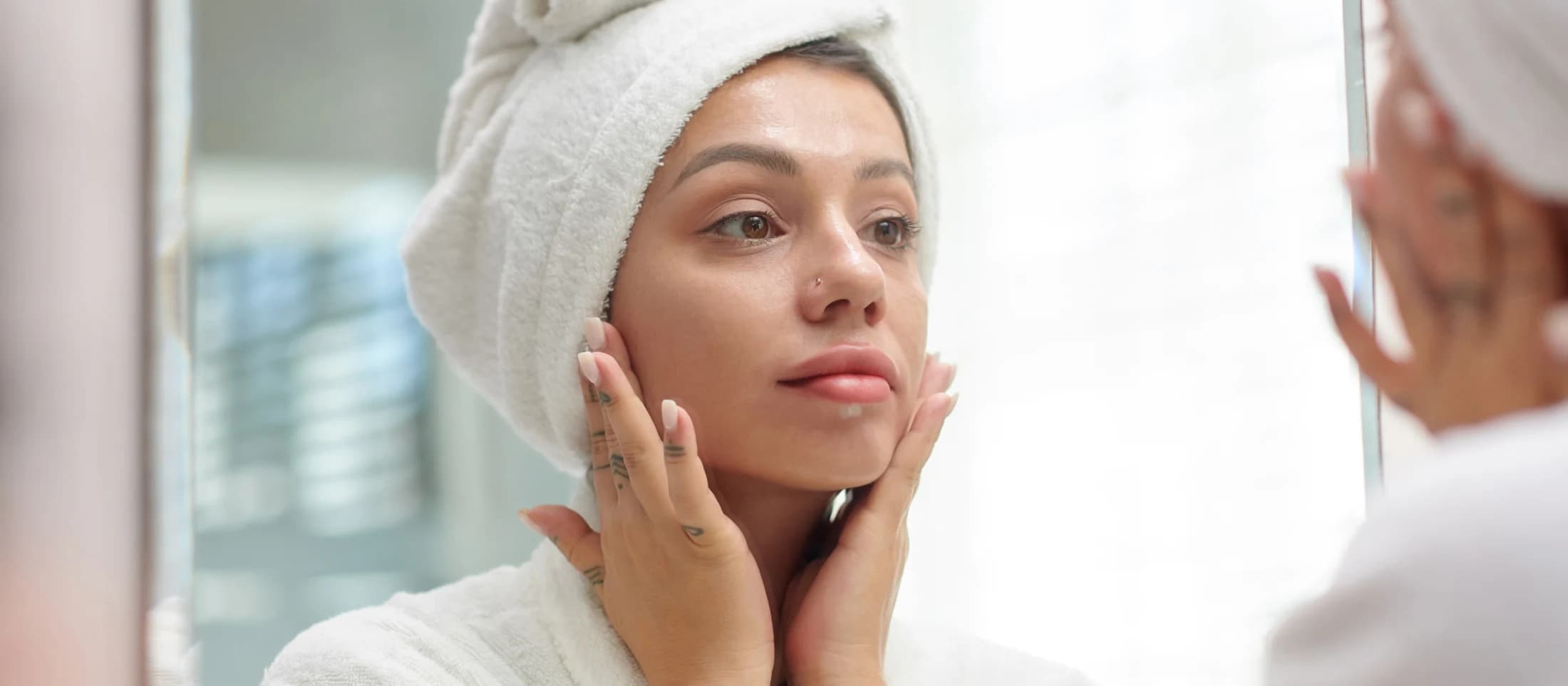 Women in bath robe looking at mirror